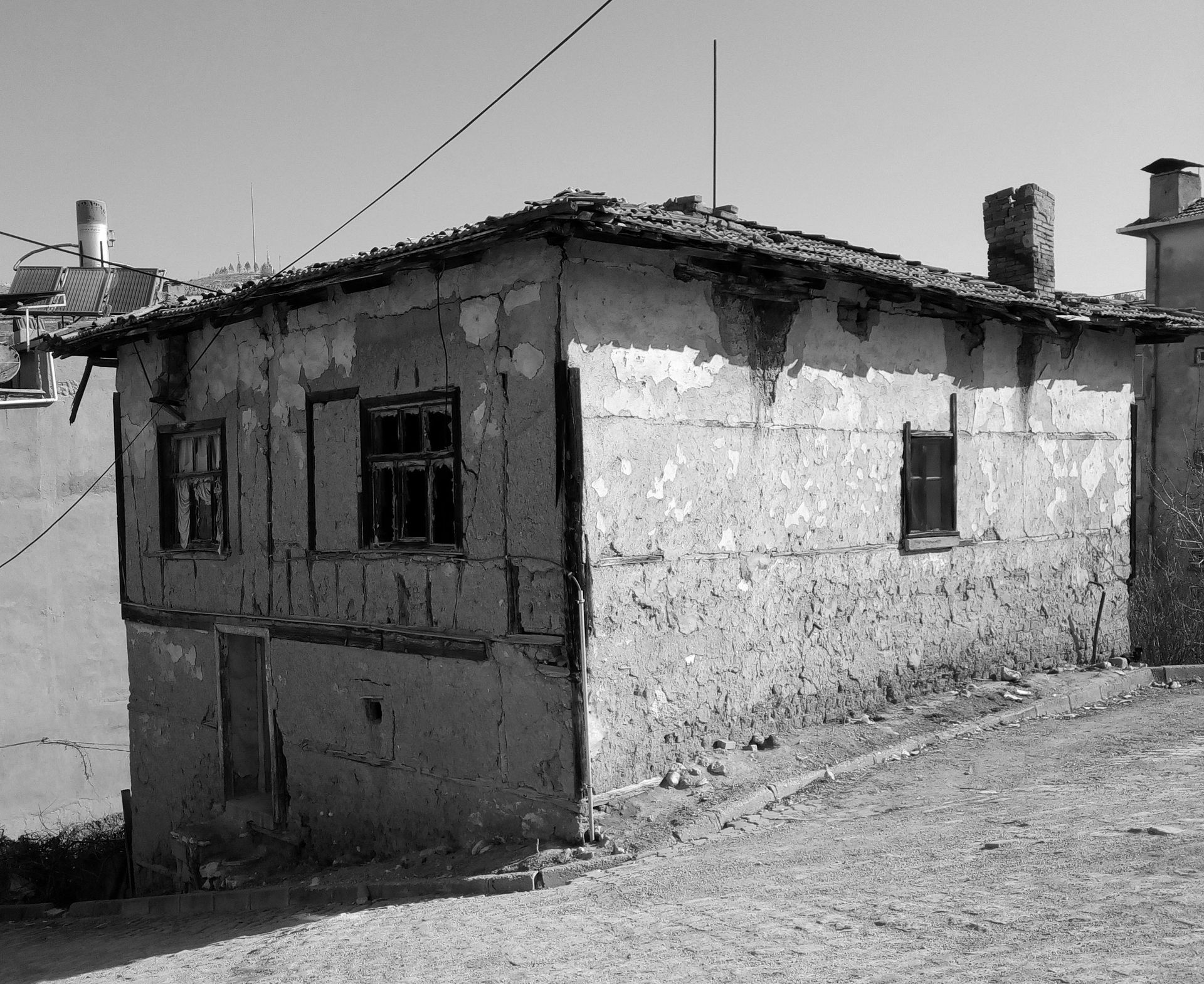 A weathered and shabby house with cracked walls on a deserted street.