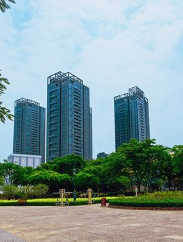 Tall skyscrapers towering over a serene urban park landscape in Vietnam.