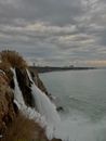 Ocean Waves Crashing on Brown Rock Formation Under White Clouds