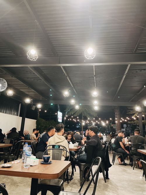 Free A contemporary restaurant filled with people enjoying meals under stylish lighting and decor. Stock Photo