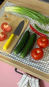 Assorted fresh vegetables on a kitchen chopping board ready for cooking.
