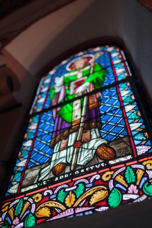 Free Colorful stained glass window depicting a saint in a Catholic church interior. Stock Photo