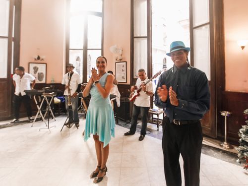 Free Energetic band and dancers performing indoors with instruments and smiles. Stock Photo