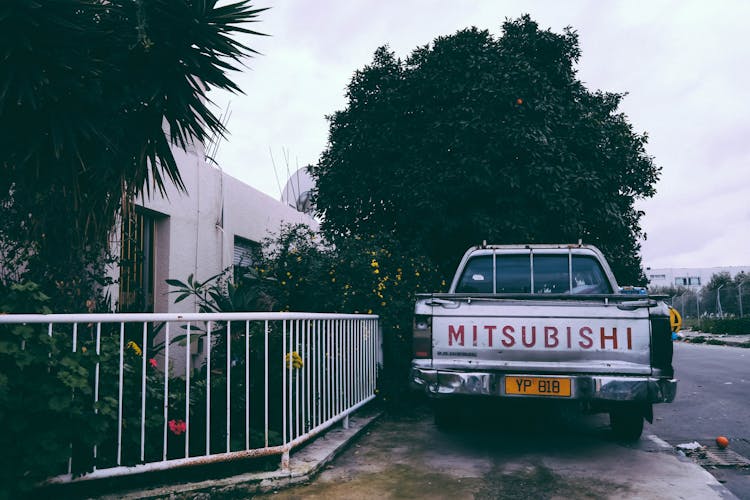 Gray Mitsubishi Car Parking Near White Hand Rails