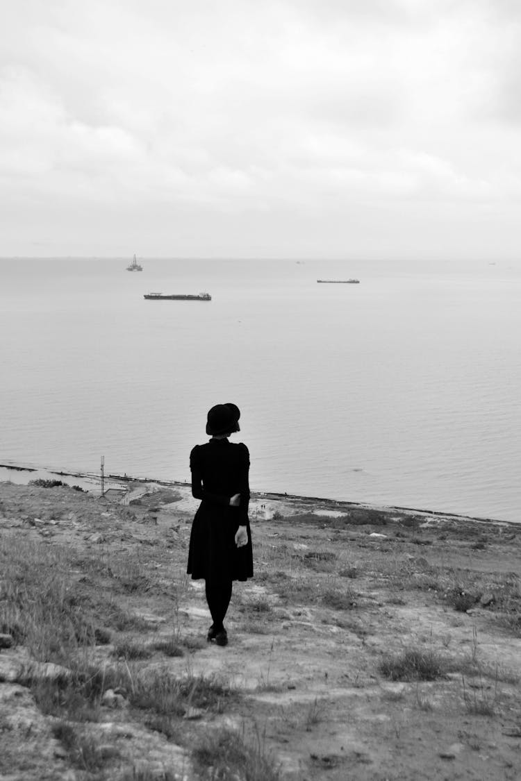 Black Silhouette Of Woman Standing At Seashore