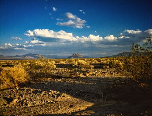 Free Discover the vast beauty of Nevada's desert under a vibrant blue sky with scattered clouds. Stock Photo