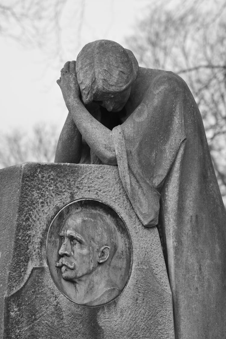 Statue Of Woman Looking Down At Man