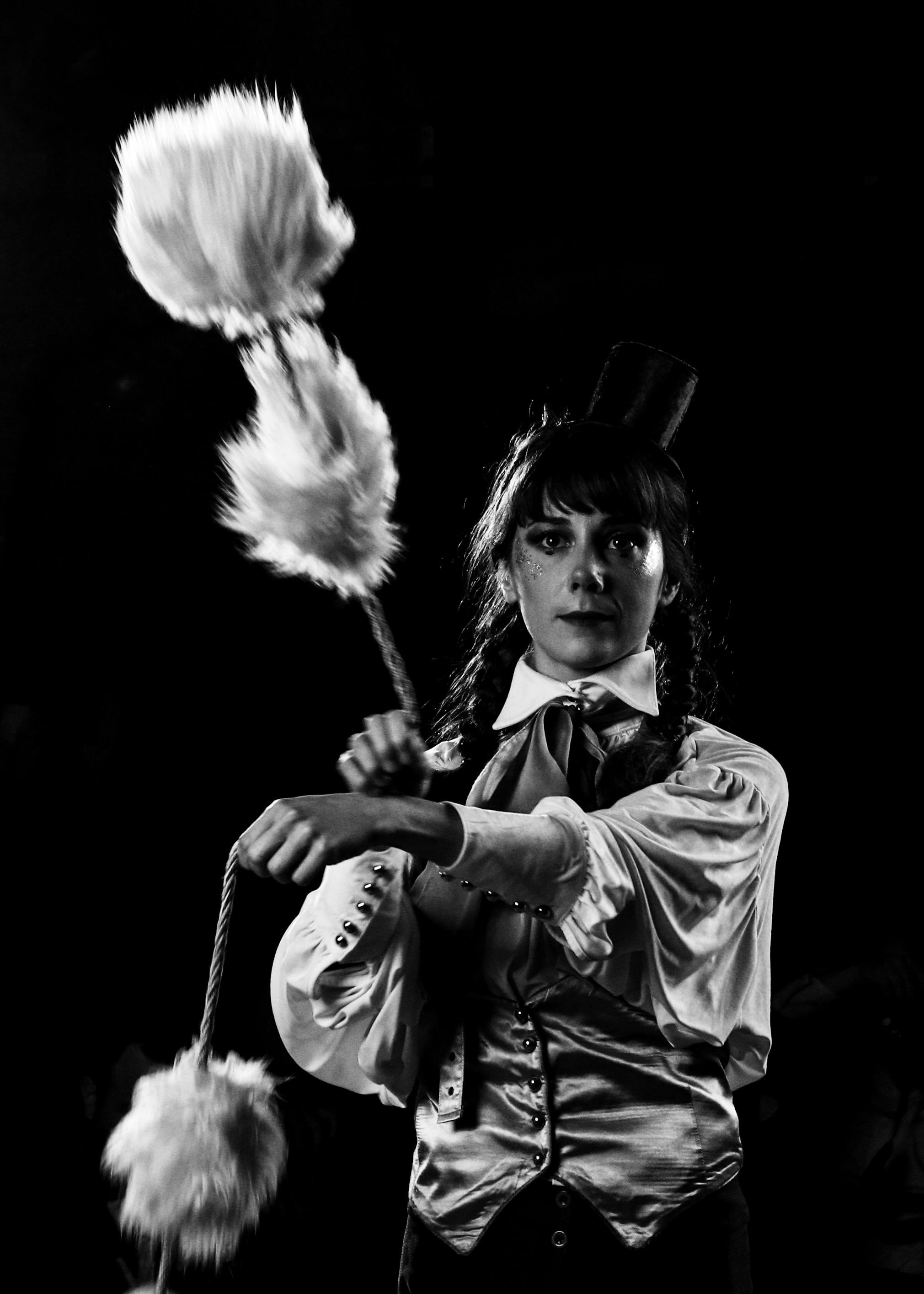 Free Black and white image of a woman performing in a dramatic circus setting. Stock Photo