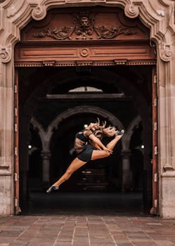 芭蕾舞演员在历史悠久的阿瓜斯卡连特斯拱门上，表演了戏剧性的跳跃