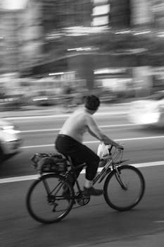 Black and white photo capturing a cyclist in motion on bustling streets of São Paulo.