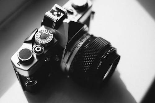 Free Black and Gray Dslr Camera on White Surface Stock Photo