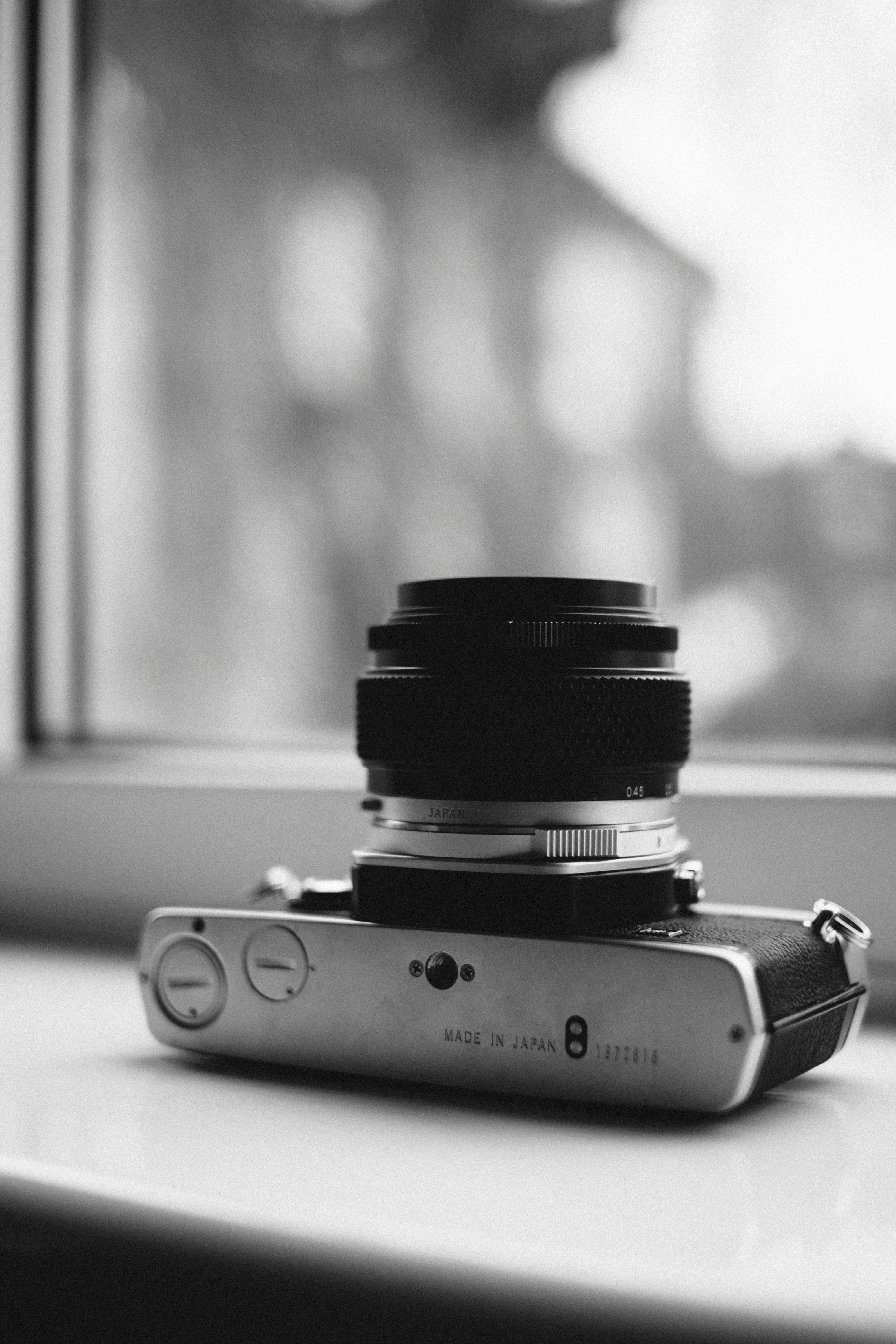 窗台上放着一台老式旁轴相机的黑白照片，展示了经典设计