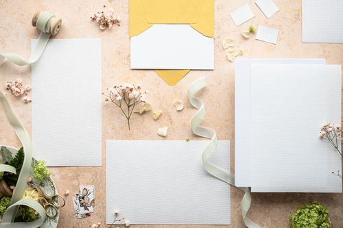 Free Flat lay of wedding invitation set with flowers and ribbon, perfect for elegant events. Stock Photo