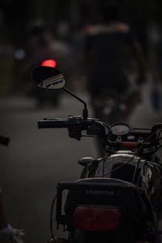 Silhouette of a motorbike with riders in Taguig, Philippines, during twilight.
