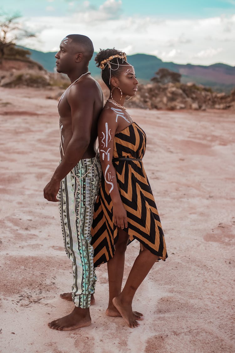 A Young Man And Woman In Ethnic Outfits Standing Back To Back