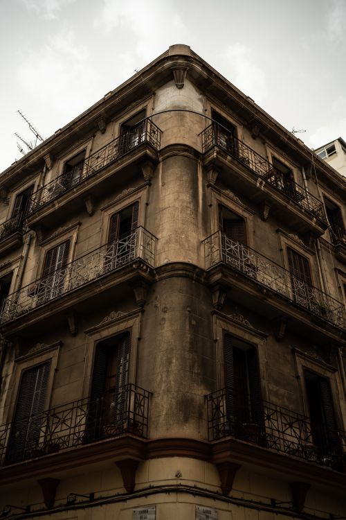 Free A historic building in Palma, Spain showcases old-world architecture with iron balconies and weathered facade. Stock Photo