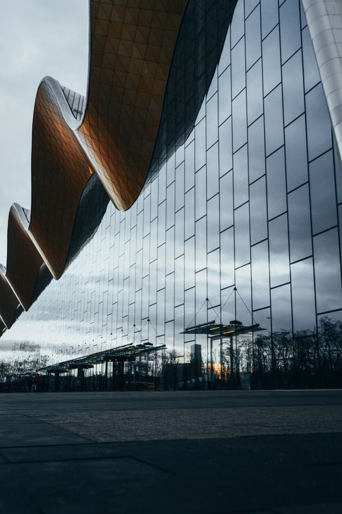 Free Low angle view of modern glass facade with reflections and curvy design in Moscow. Stock Photo