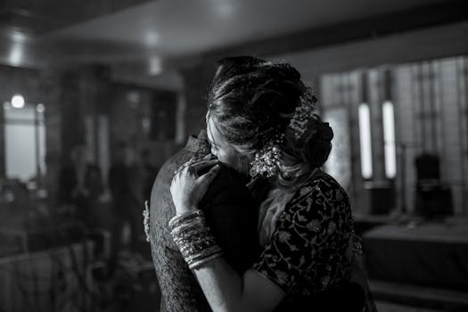 A couple embraces while slow dancing in an elegant setting.