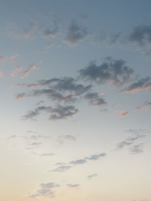Free A serene sky filled with scattered clouds at dusk, capturing a peaceful moment. Stock Photo