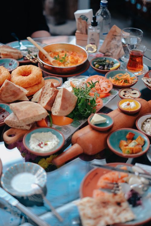 Free A vibrant spread of Middle Eastern dishes arranged on a dining table, showcasing an assortment of breads, dips, and pickles. Stock Photo