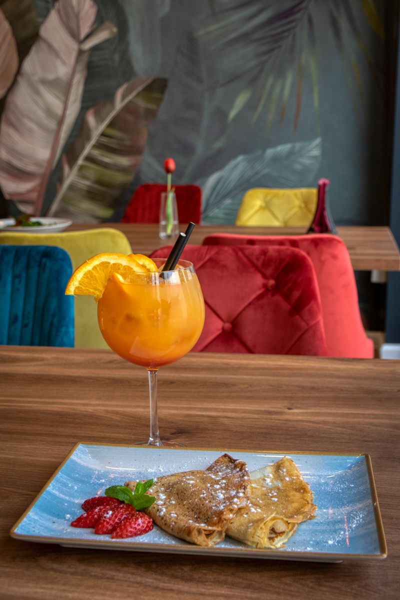 Mesa con comida y vaso de zumo de naranja