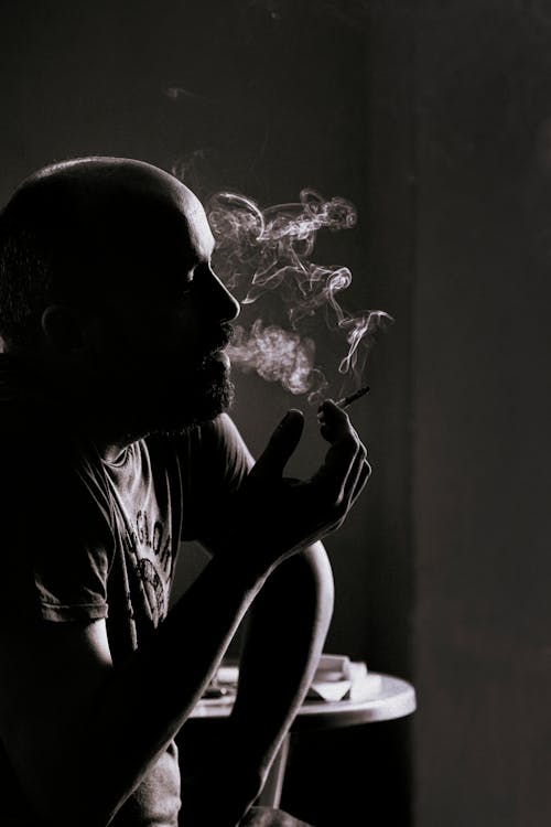 Grayscale Photo of a Man Smoking 