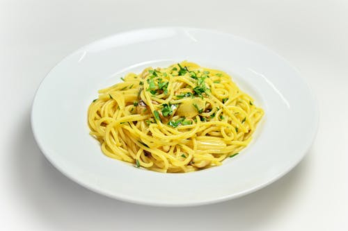 Free Spaghetti Aglio e Olio with Chopped Basil on White Plate Stock Photo