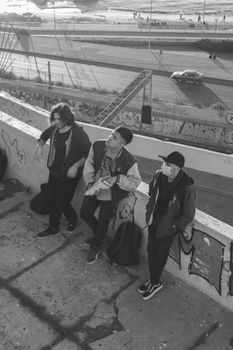 Three friends enjoying the view from Valparaíso seafront graffiti wall in grayscale.