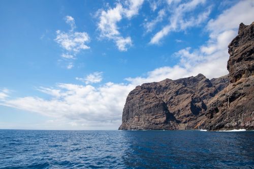 Free Dramatic cliffs of Los Gigantes rising above the ocean in Tenerife under a vivid blue sky. Stock Photo