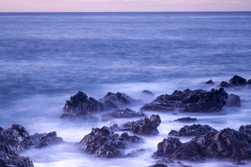 Free A tranquil seascape capturing rocks and ocean waves in a long exposure. Stock Photo