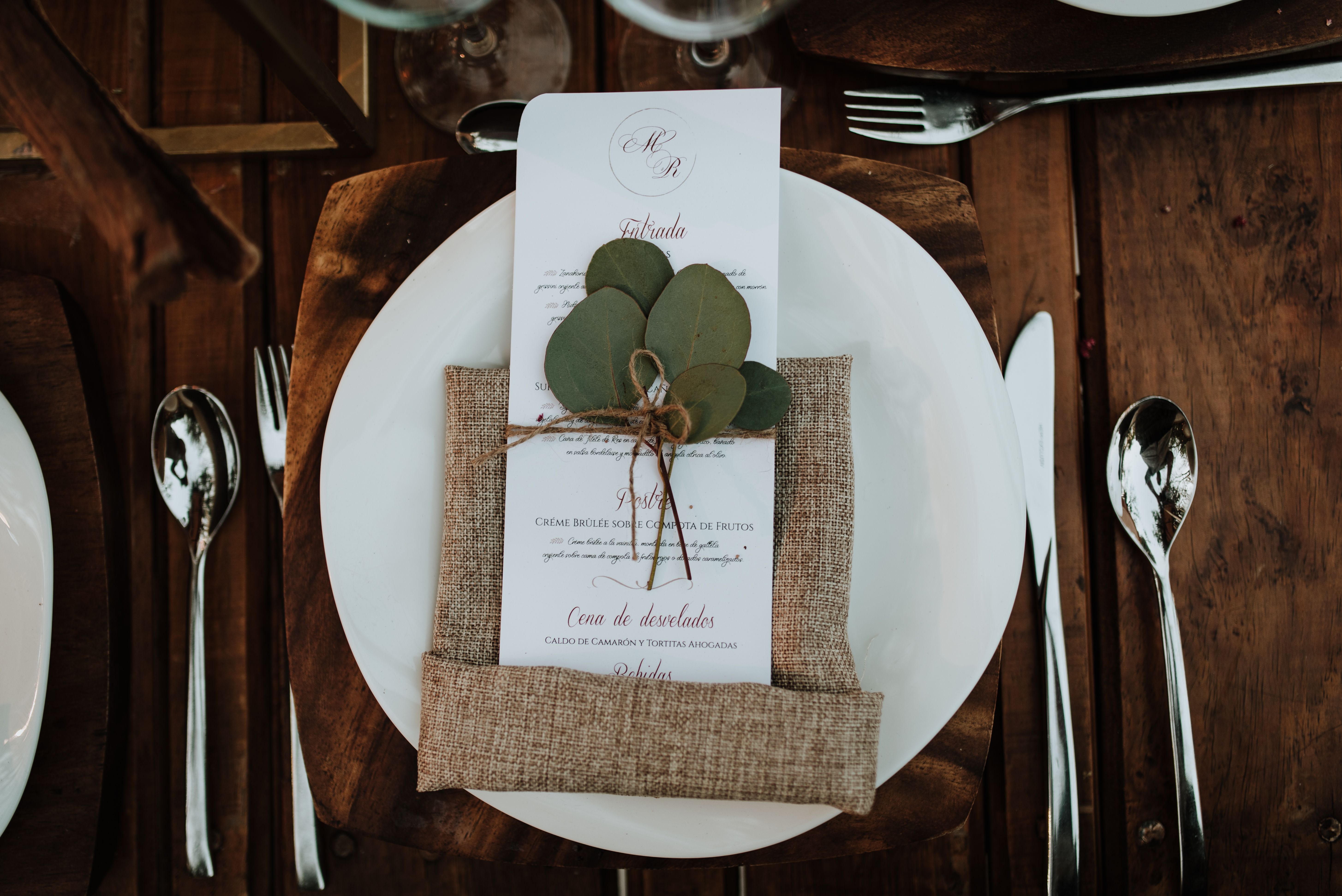 A printed wedding dinner menu card at a reception table place setting
