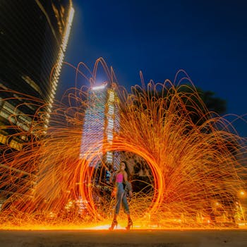 Captivating night shot of a young woman in Mexico City surrounded by vibrant firework sparks.