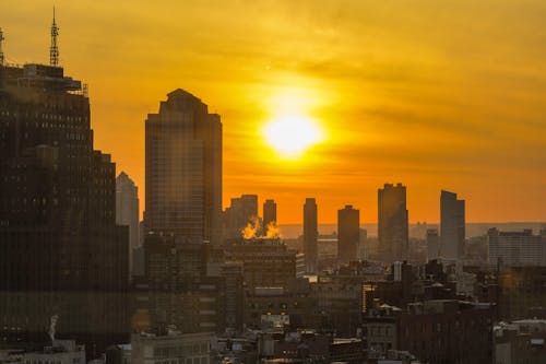 Free City Skyline during Sunset With Yellow and Orange Sky Stock Photo