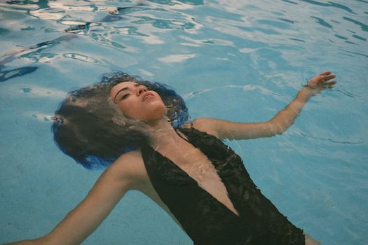 Woman Floating in Swimming Pool