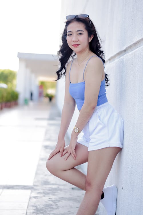 A Woman in Blue Spaghetti Strap Top and White Shorts