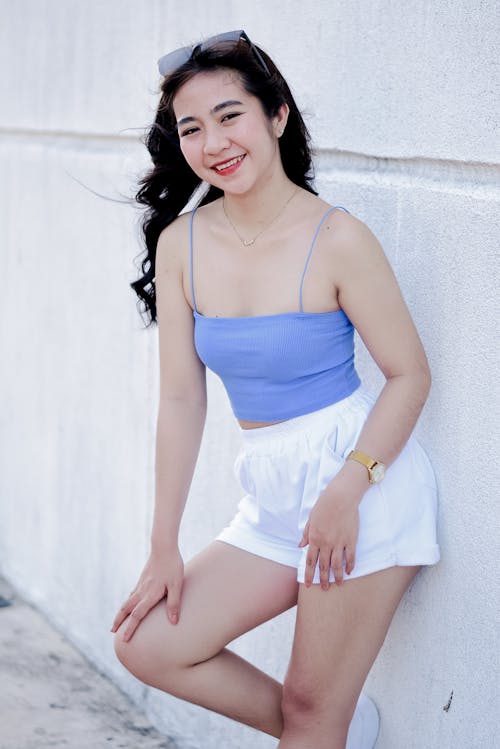 A Woman in Blue Spaghetti Strap Top and White Shorts