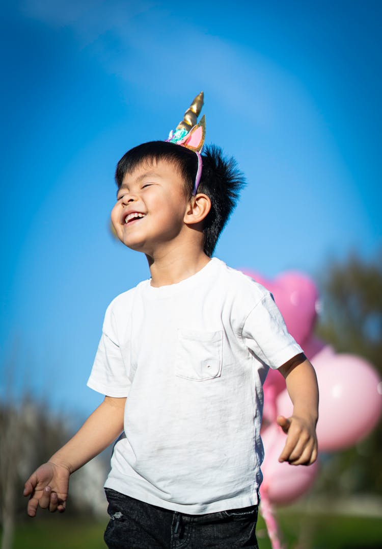 Smiling Boy With Unicorn Horn On His Head 