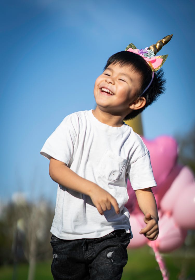 Smiling Boy With Unicorn Horn On His Head 