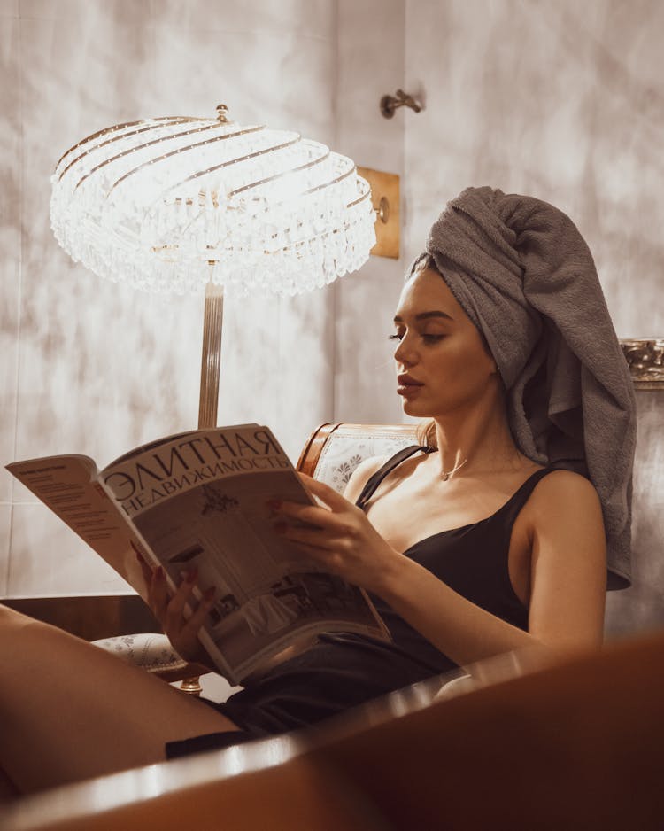 Woman With Towel On Her Head Reading A Magazine