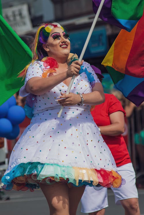 Женщина в разноцветном платье в горошек с флагом