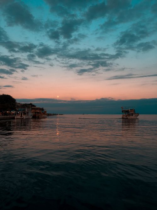 Free Calm evening view of boats on the tranquil Sinop harbor during sunset. Stock Photo