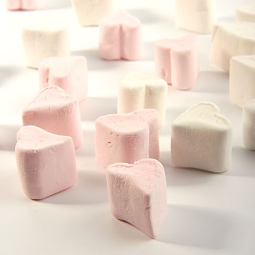 Free Heart-shaped pink and white marshmallows arranged on a white surface, ideal for romantic themes. Stock Photo