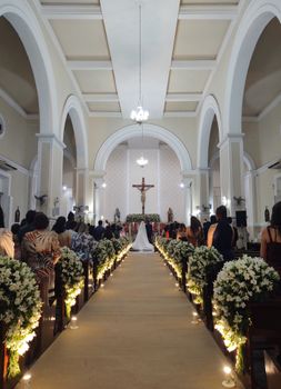 A beautifully decorated church wedding ceremony with a bride walking down the aisle adorned with flowers.