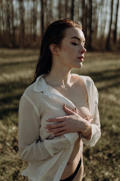 Young Partly Dressed Woman Covering her Breasts with Hands