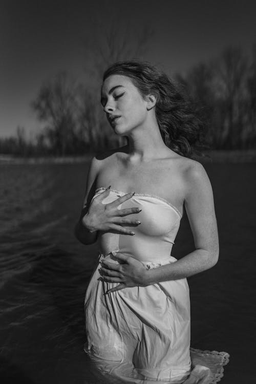 Woman Standing in Water in Wet White Dress