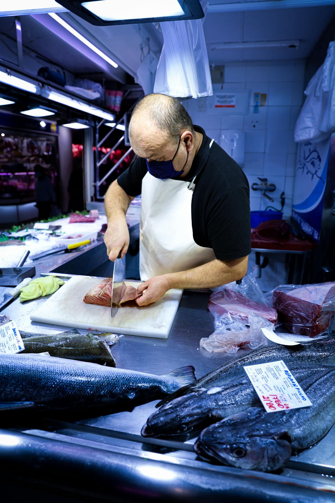 Persona che sfiletta un pesce su un piano di taglio
