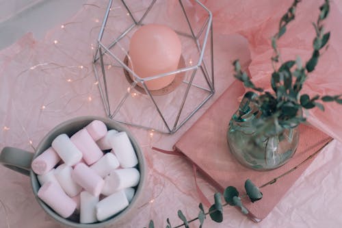 Cup with Marshmallows and Candle on Table