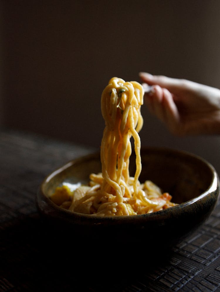 Person Eating Asian Noodles