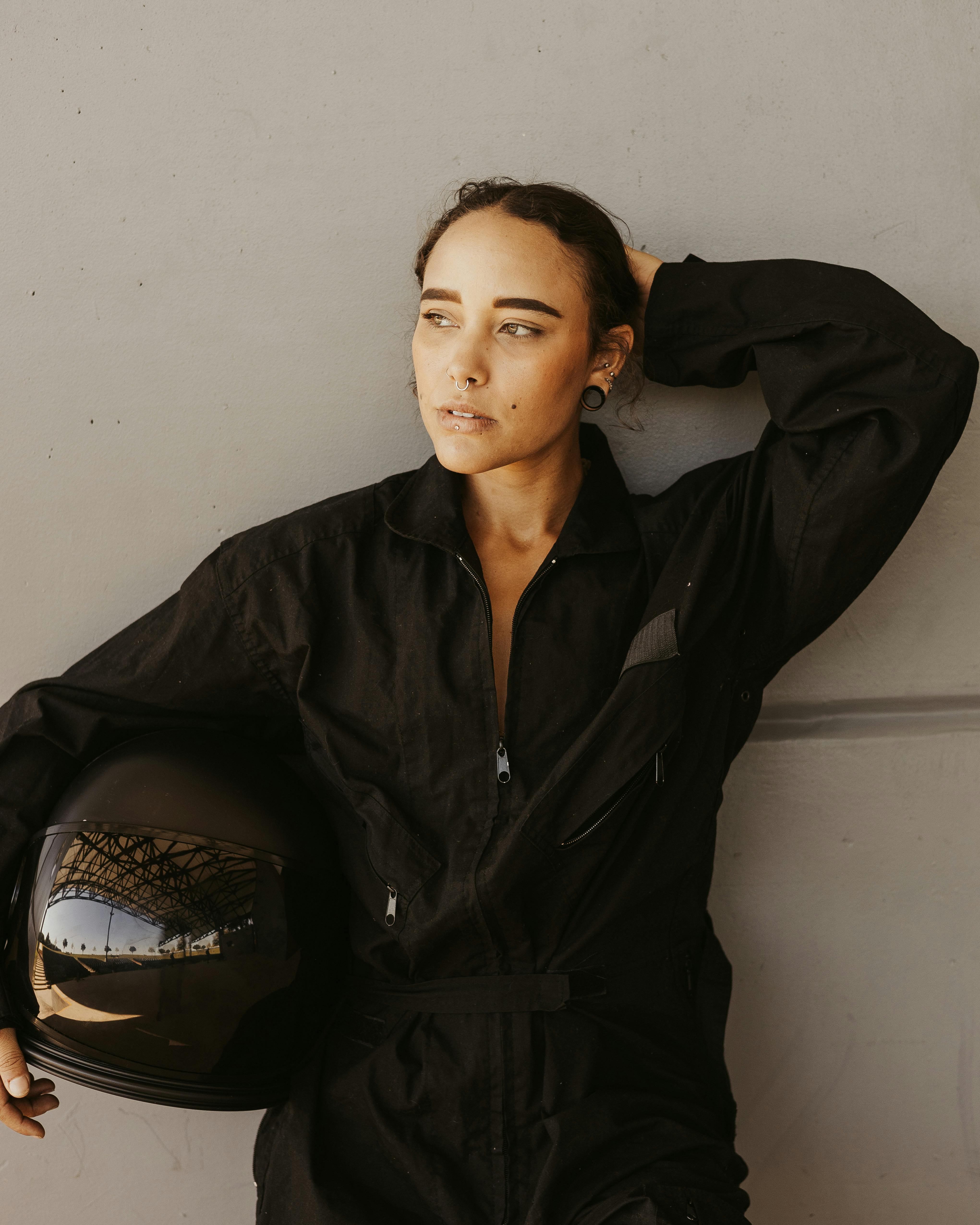 Woman in Racing Suit Holding a Helmet · Free Stock Photo