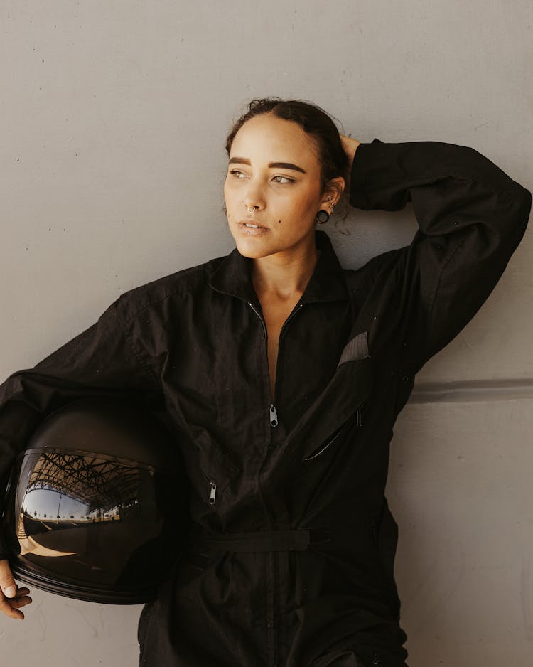 Woman In Racing Suit Holding A Helmet 